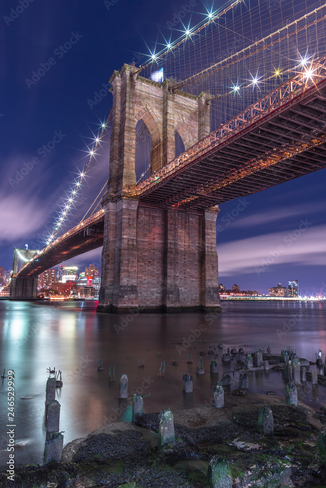 Fototapeta premium View on Brooklyn bridge from east river at night with long exposure