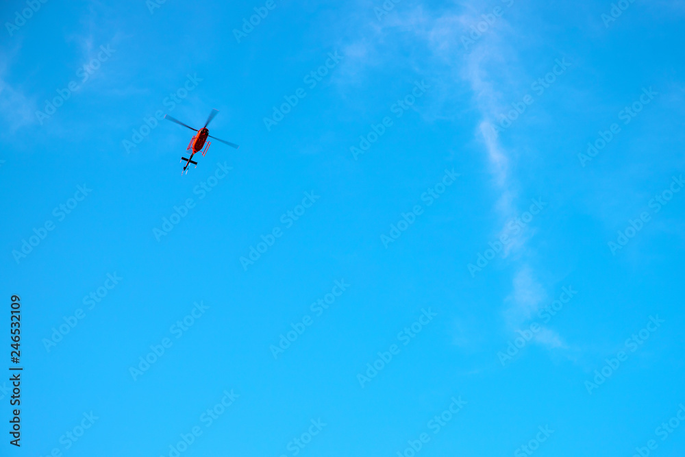 Red helicopter in blue sky. Emergency service helicopter flight. Red helicopter banner template with text place. Red helicopter in blue sky. Emergency service helicopter flight. Red helicopter banner template with text place.