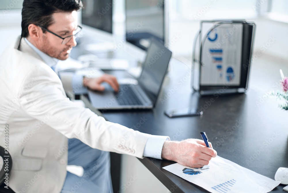 Fototapeta premium businessman writing down information in a notebook
