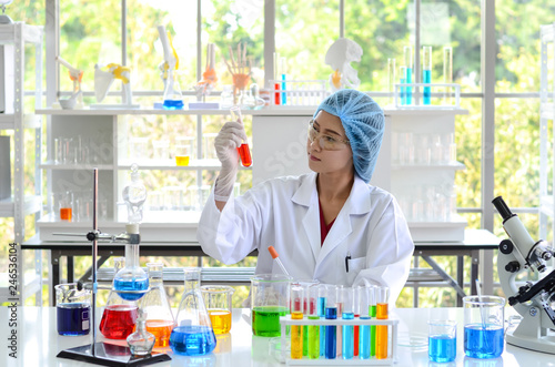 The woman scientist in laboratory doing experiments with chemical liquid by using the test tube.