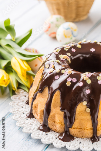 Delicious holiday slovak and czech cake babovka with chocolate glaze. Easter decorations - spring tulips and eggs photo