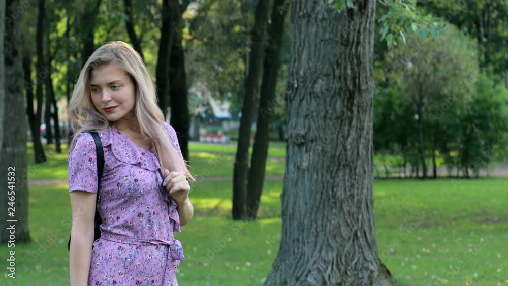 The girl is waiting for a meeting with her boyfriend. Summer day in the park. The girl is waiting for a meeting with her boyfriend. Summer day in the park.