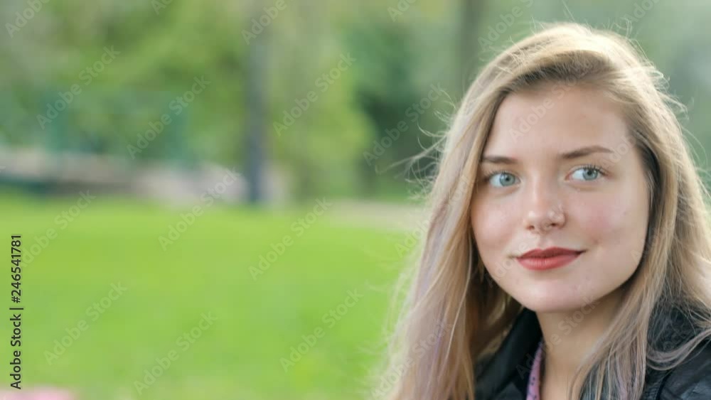 The girl is waiting for a meeting with her boyfriend. Summer day in the park. The girl is waiting for a meeting with her boyfriend. Summer day in the park.