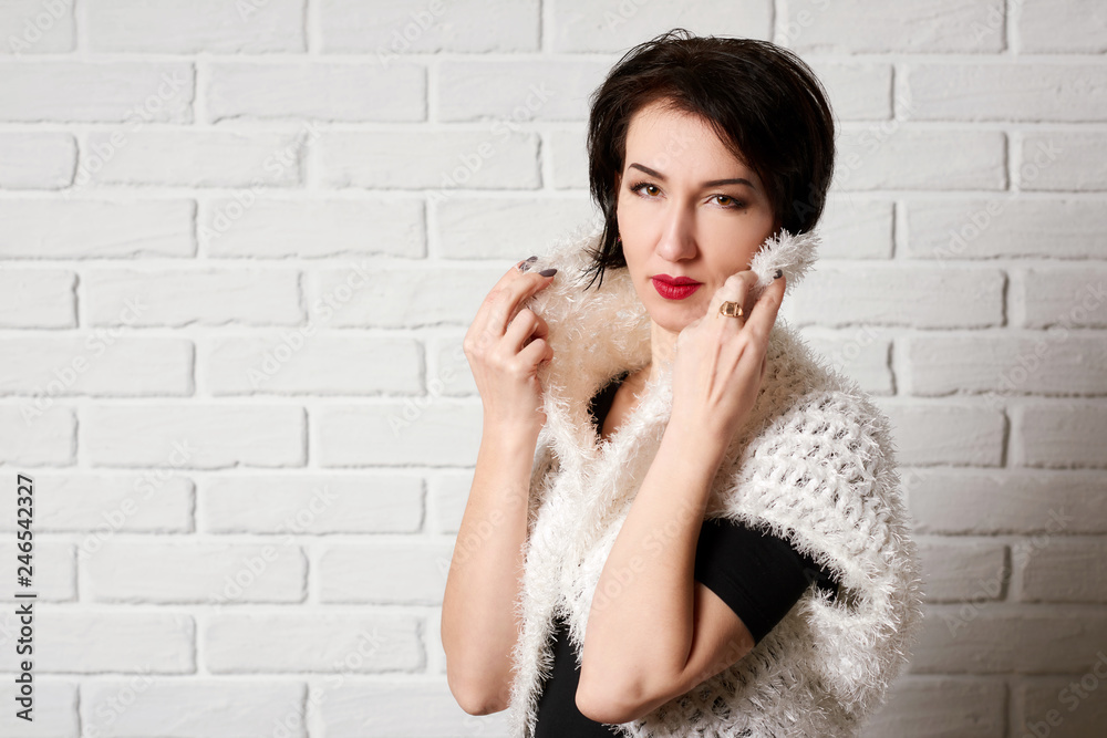 Beautiful woman posing near white brick wall background Beautiful woman posing near white brick wall background