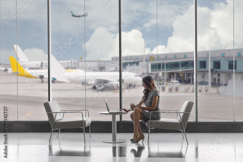 First class business passenger sitting in luxury VIP exclusive lounge at airport, on laptop