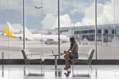 First class business passenger sitting in luxury VIP exclusive lounge at airport, on laptop photo