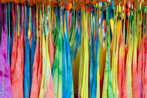 Summer clothes on hangers for sale in local street market in Thailand, close up