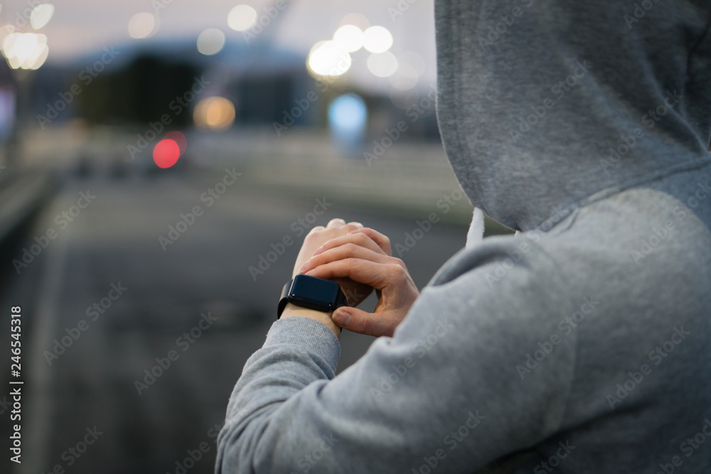 Woman athlete using smart watch activity tracker time and gps during running training.