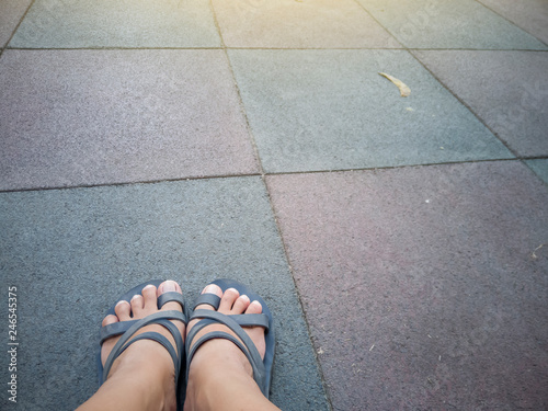 Women wearing sandals on the rubber flooring tiles in playground.