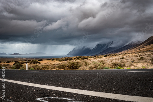 Huge and beautiful storm over Playa Famara beach and in Lanzarote, and La Graciosa Island. Beautiful thunderstorm in Canary Islands. Rain in the background photo