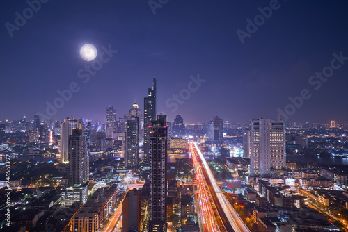 scenic of night cityscape with full moon on twilight skyline