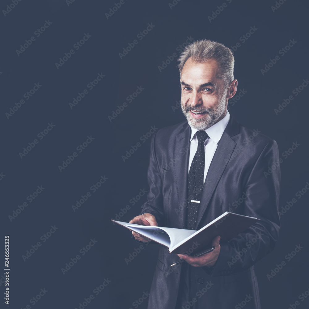 successful businessman with pen and papers ready for signature on a black background successful businessman with pen and papers ready for signature on a black background