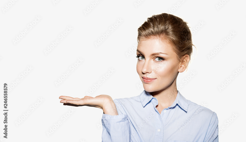 Portrait of well-dressed female presenting your product on palm. Attractive model looking at camera. Copy space in left side. Isolated on white background Portrait of well-dressed female presenting your product on palm. Attractive model looking at camera. Copy space in left side. Isolated on white background