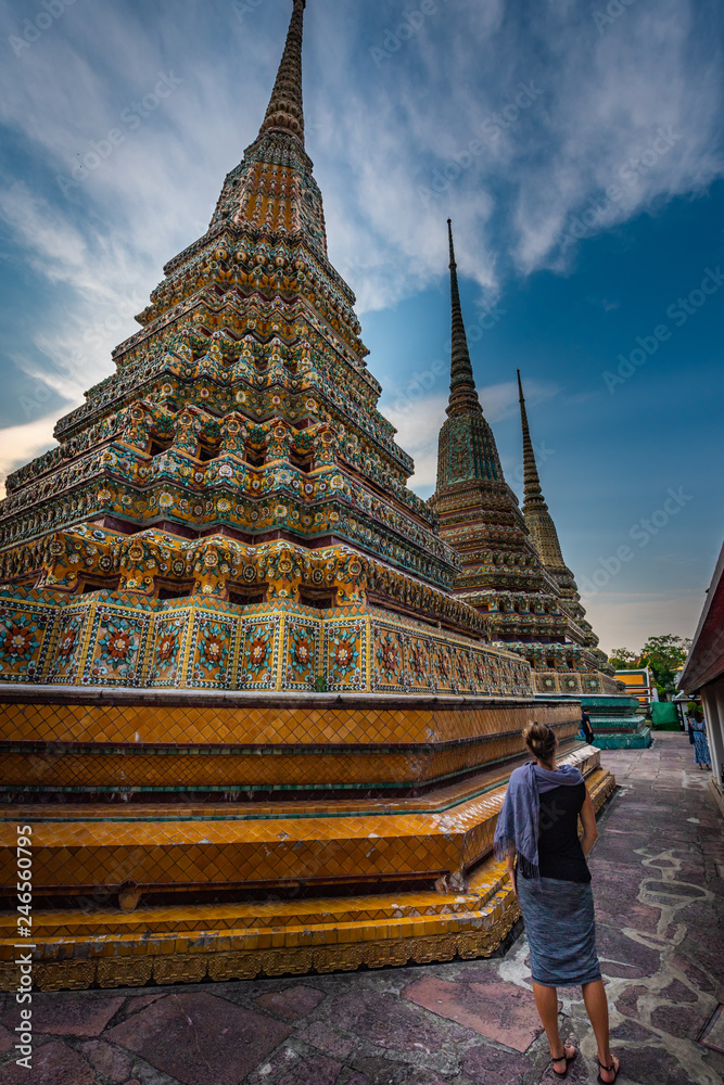 Fototapeta premium Woman Tourist admires Wat Pho Temple Bangkok Thailand