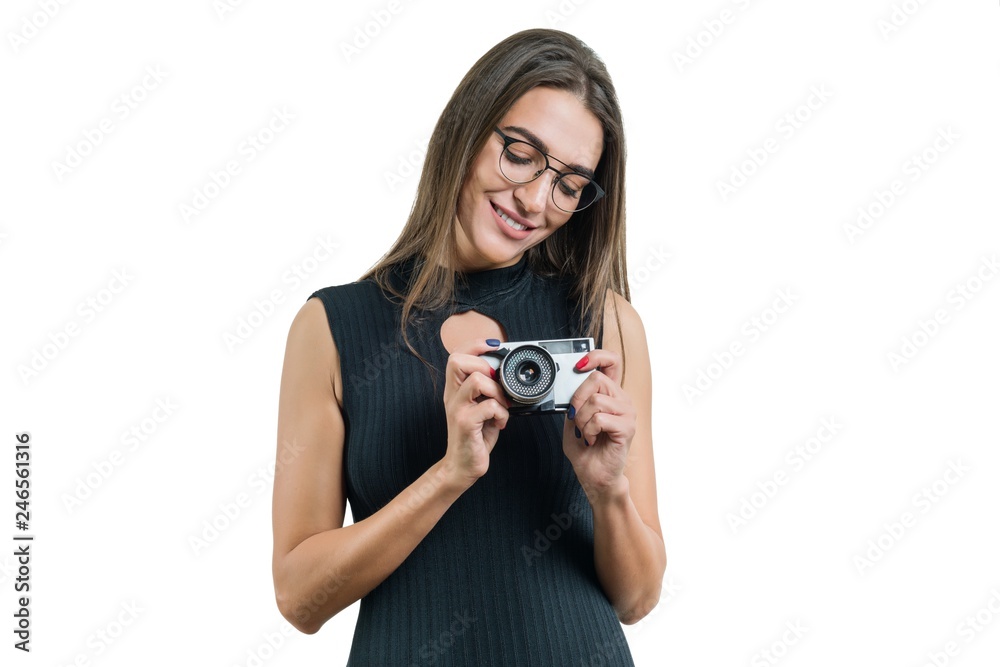 Young smiling beautiful woman in black dress glasses holding photo camera in her hands, taking photo, on white isolated background Young smiling beautiful woman in black dress glasses holding photo camera in her hands, taking photo, on white isolated background