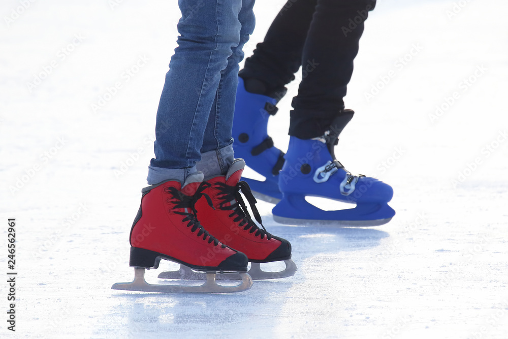 feet of different people skating on the ice rink feet of different people skating on the ice rink