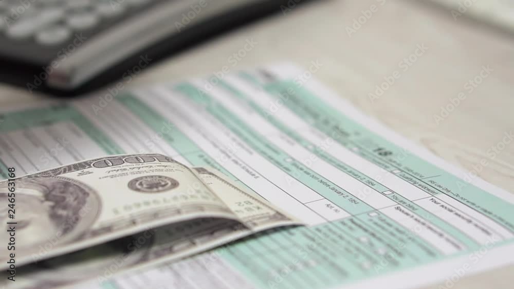 Slow motion of counting money and falling slowly on the tax form 1040. Slow motion of counting money and falling slowly on the tax form 1040.