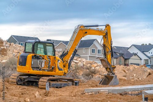 Excavator with Utah Valley homes in background photo