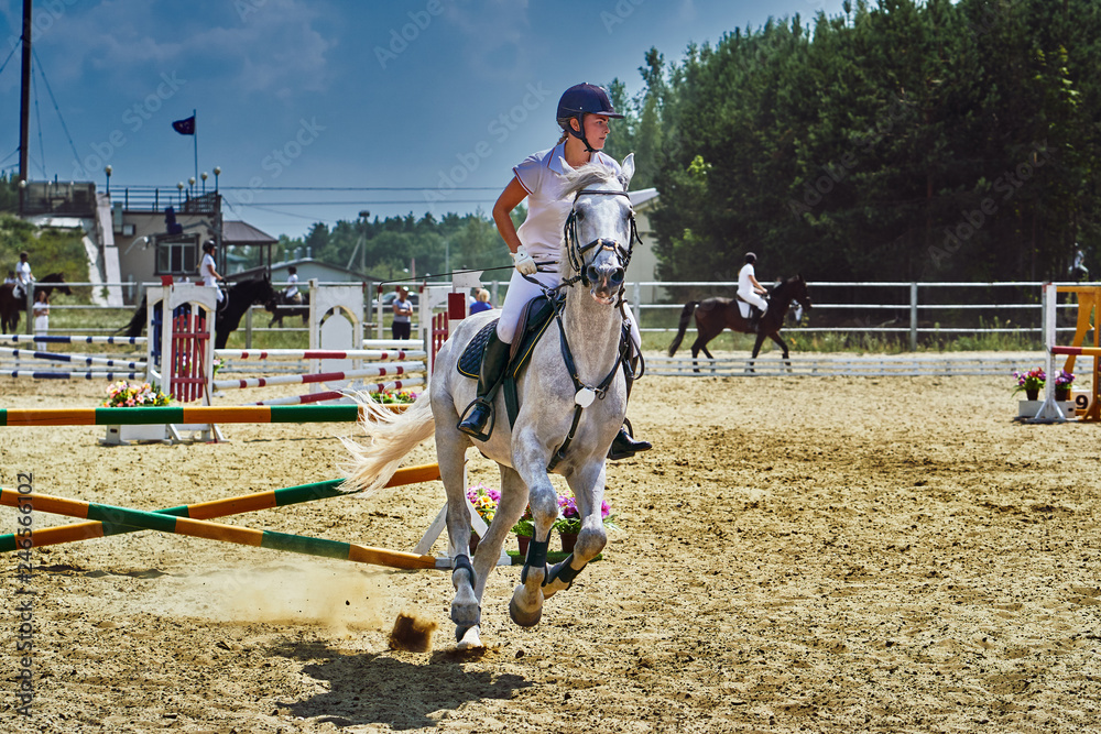 Young woman jockey in white dress and black boots, takes part in equestrian competitions. Close-up. Young woman jockey in white dress and black boots, takes part in equestrian competitions. Close-up.