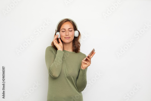 portrait of a young smiling woman with headphones and mobile phone 