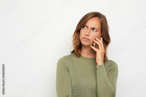 portrait of young woman with mobile phone looking upset