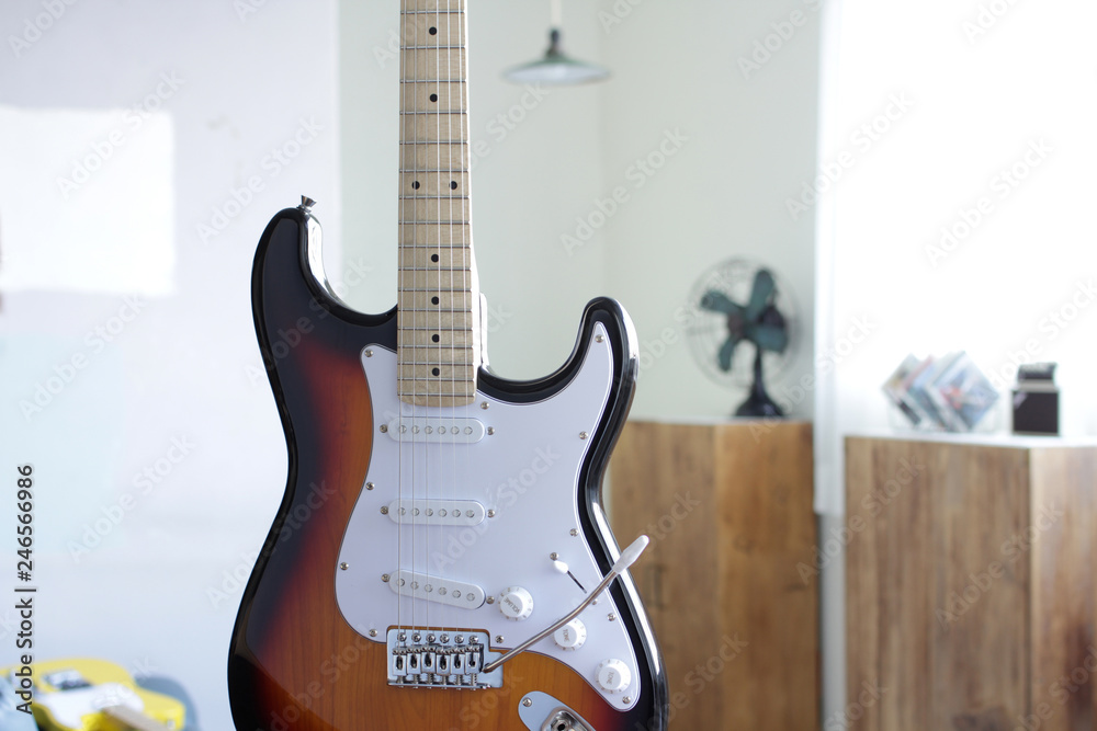Fototapeta premium 光の差し込む明るい部屋にあるエレキギター