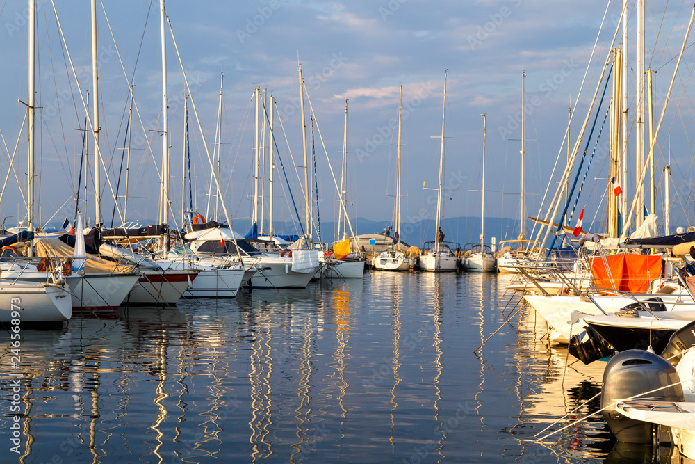 Yachts and boats in the harbor at sunset, reflection, beautiful coastal view, French Riviera. Holidays in France. Yachts and boats in the harbor at sunset, reflection, beautiful coastal view, French Riviera. Holidays in France.