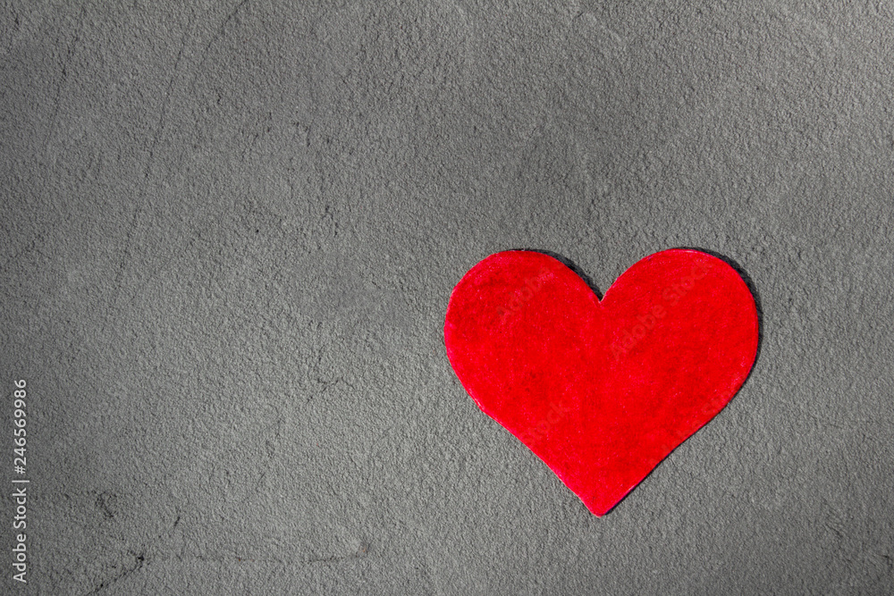 Obraz premium Czerwone serce papieru na szarej ścianie z miejsca na kopię Happy Valentine tła