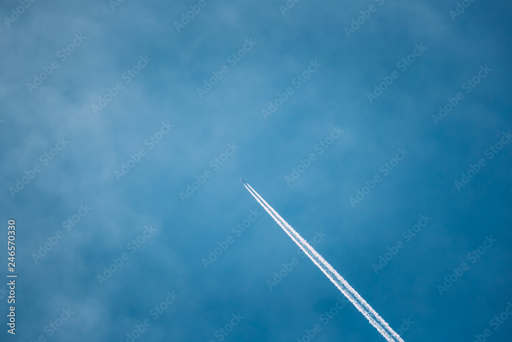 Contrail In Blue Sky. Plane In Sunny Sky Background. Airplane Aircraft In Sky With Trails Contrail In Blue Sky. Plane In Sunny Sky Background. Airplane Aircraft In Sky With Trails