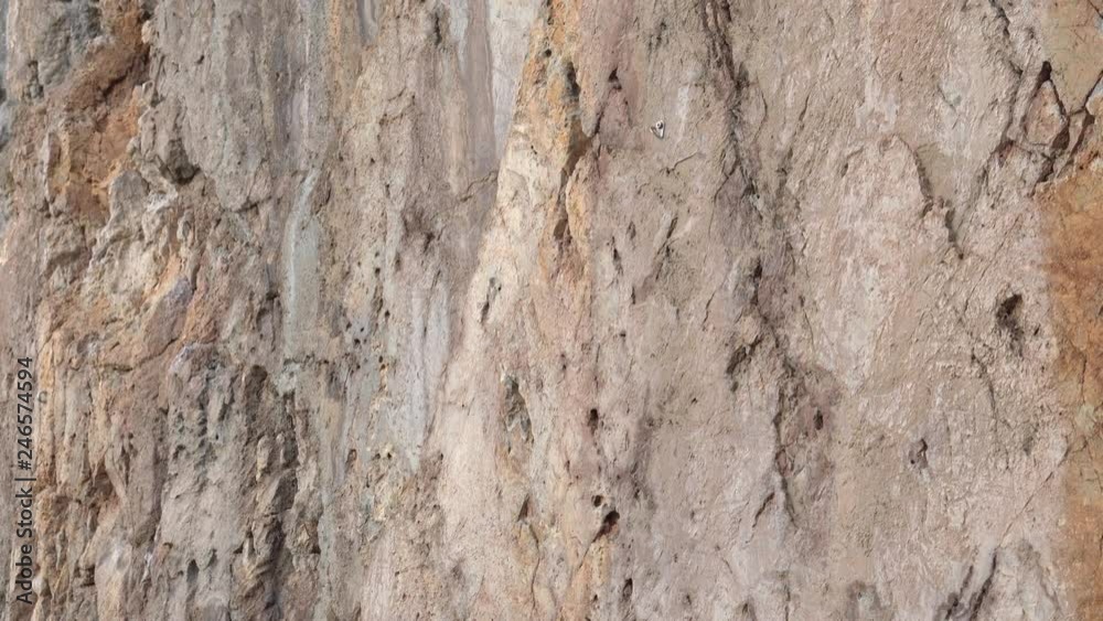 Sheer wall in the mountains broken rock climbers. A place to practice rock climbing. Brown flat stone surface. Close up Sheer wall in the mountains broken rock climbers. A place to practice rock climbing. Brown flat stone surface. Close up