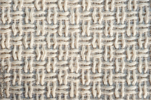 Textured fabric mat with woven wool beige yarn closeup shot..