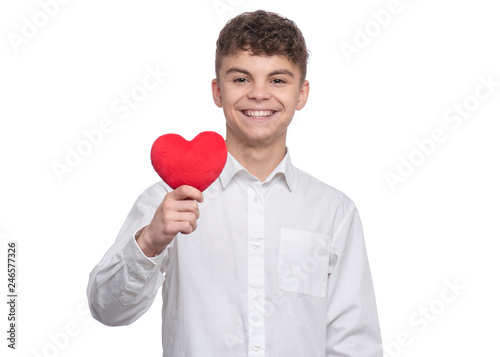 Happy Valentines Day. Cute young Teen Boy in Love with Red plush Heart in his hands. Smiling Child looking at camera, isolated on white background.