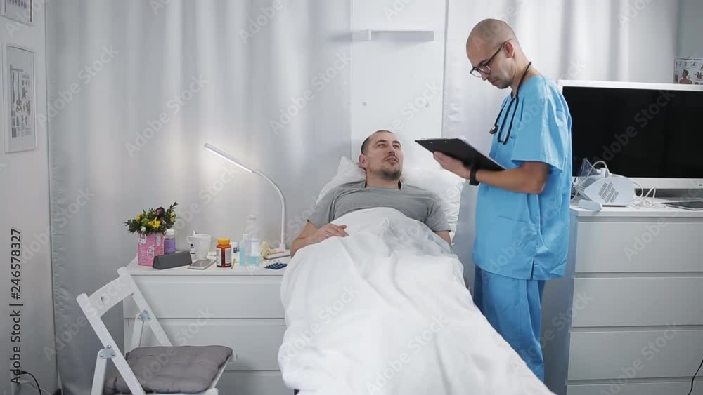 Doctor with a patient. Young male doctor checking patient's health in bed in hospital. The concept of medical care. Doctor with a patient. Young male doctor checking patient's health in bed in hospital. The concept of medical care.