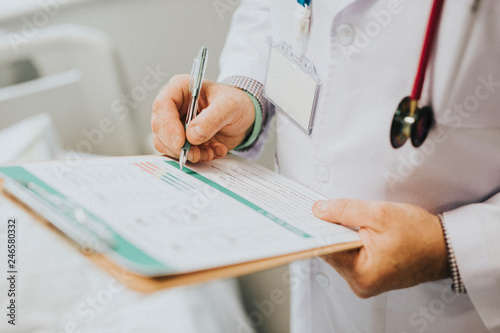 Physician noting down symptoms of a patient photo