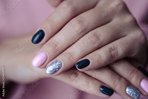 Gorgeous manicure, pastel tender pink color nail polish, closeup photo. Female hands over simple background