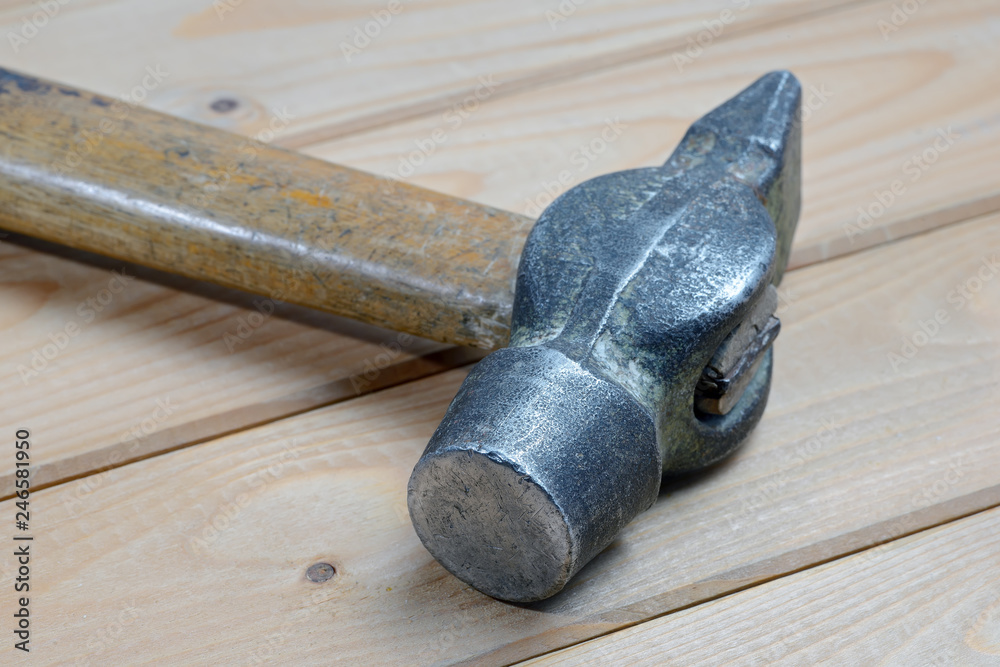 Old vintage hammer on wooden background. Close up