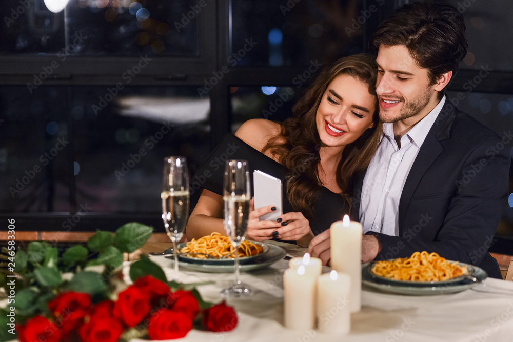 Happy couple using smartphone in restaurant Happy couple using smartphone in restaurant