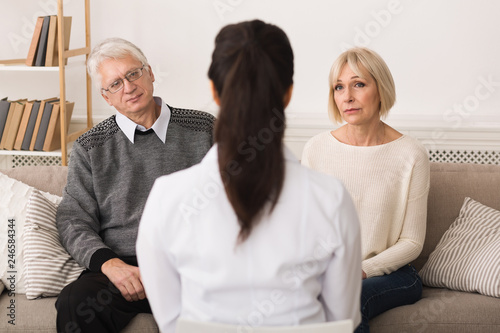 Doctor talking to senior couple at home