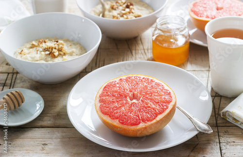 Vegetarian breakfast for two of oatmeal, baked grapefruit and tea. Rustic style.