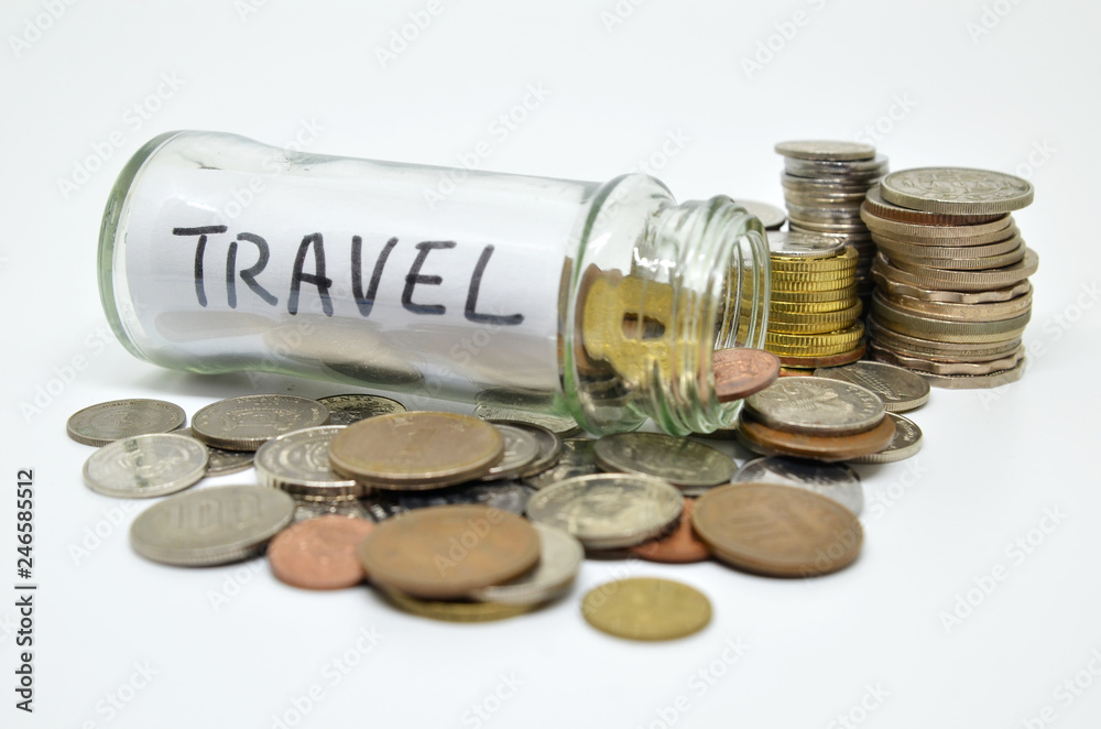 Travel lable in a glass jar with coins spilling out Travel lable in a glass jar with coins spilling out
