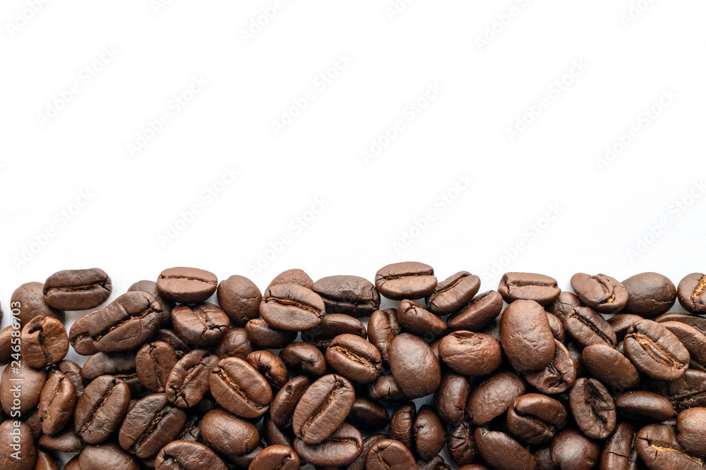Naklejka premium Roasted coffee beans on white background. Close-up.