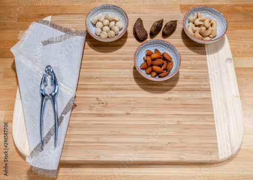 Some kind of the nuts, walnuts, almond, hazelnut with the equipment to open the nuts and on the wooden desk