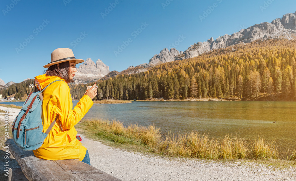 Young happy asian woman travel at the famous tourist destination in Dolomites mountains - Misurina lake during autumn. Young happy asian woman travel at the famous tourist destination in Dolomites mountains - Misurina lake during autumn.