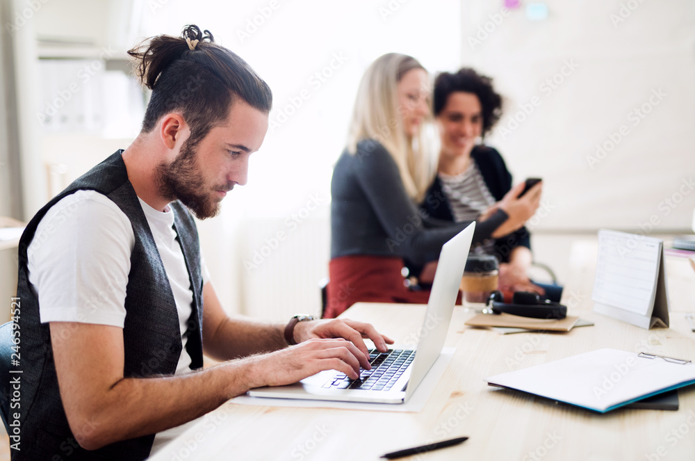 Group of young businesspeople with laptop working in a modern office. Group of young businesspeople with laptop working in a modern office.