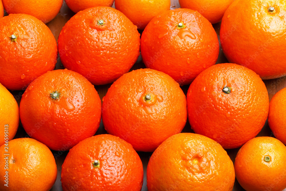 whole tangerine on the table with drops of water on the peel whole tangerine on the table with drops of water on the peel