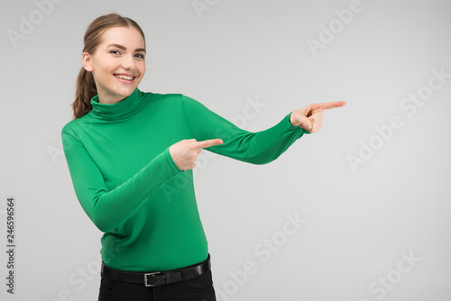 Cheerful young girl standing happily points out . - Image photo