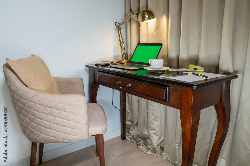 Home office notebook and cellphone with green screen
