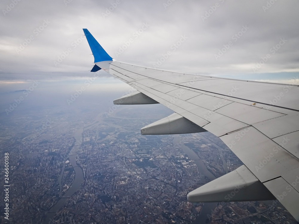 Fototapeta premium View from the window of an airplane taking off with a wing - a flight over the city.