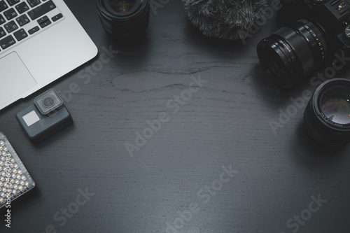 GoPro, MacBook Air, camera lens on lights on dark wooden desk