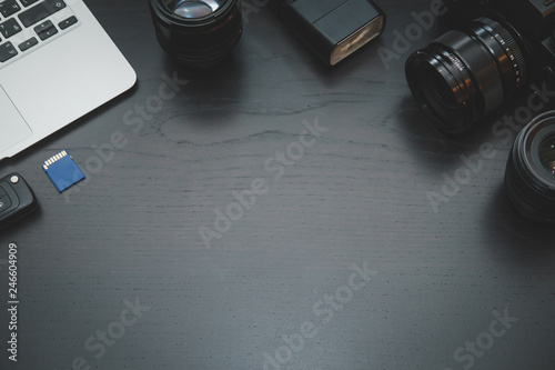 MacBook Air, camera lens on lights on dark wooden desk photo